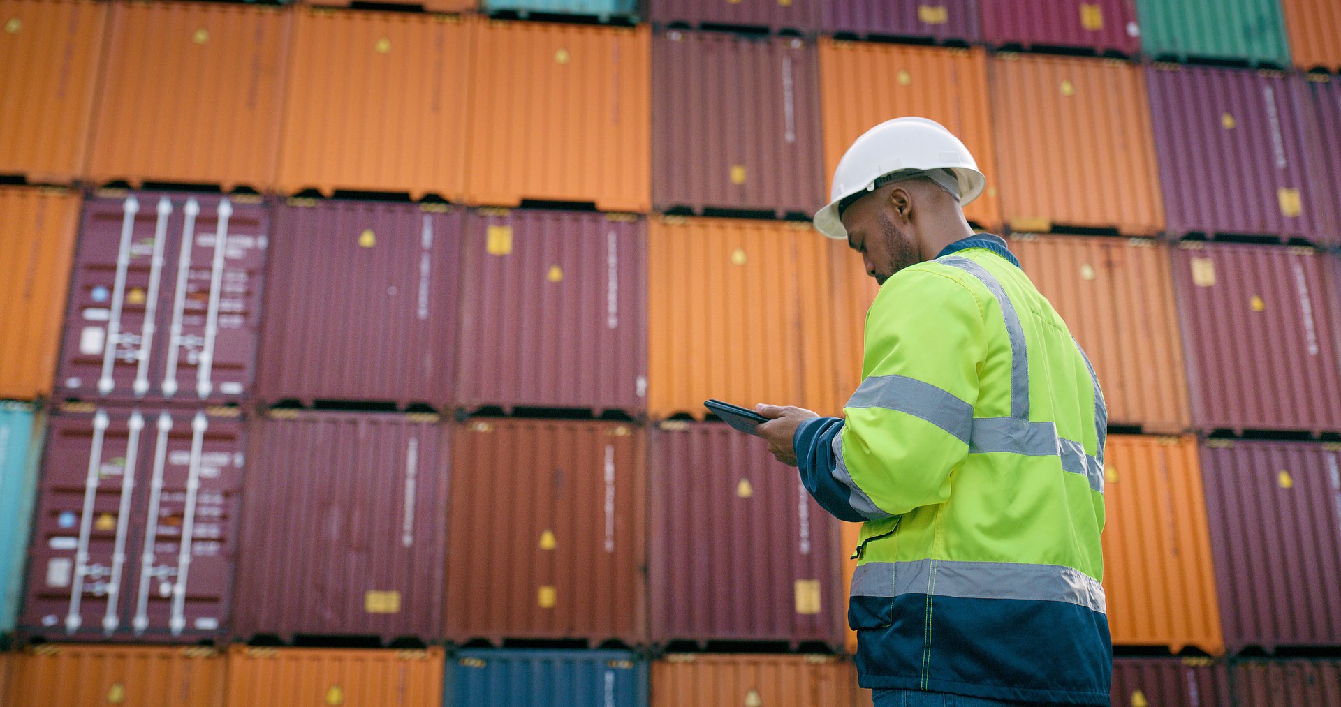 Container, freight and tablet with man at shipping yard for logistics or supply chain. Checklist, inventory inspection and storage with dock worker for management of delivery, export or import